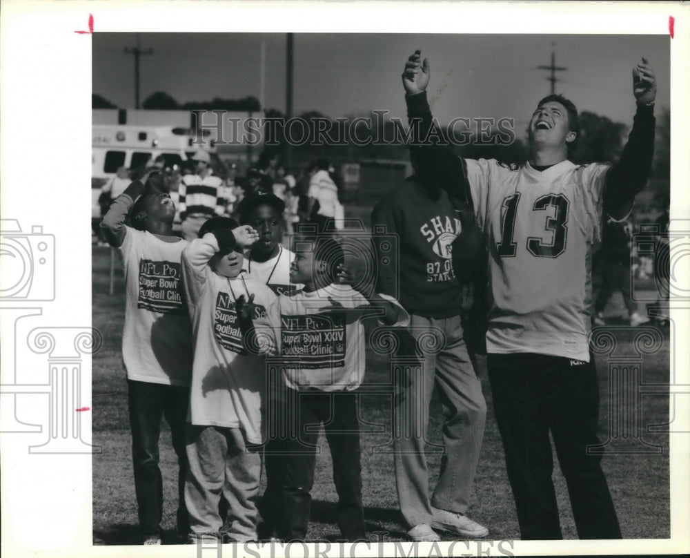 1990 Press Photo Miami Dolphin Quarterback Dan Marino reacts to a play with Kids - Historic Images