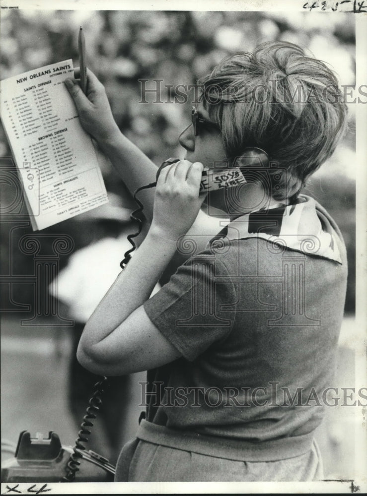 1969 Press Photo Publications Director Pat Cross reads the results of Coin Toss - Historic Images