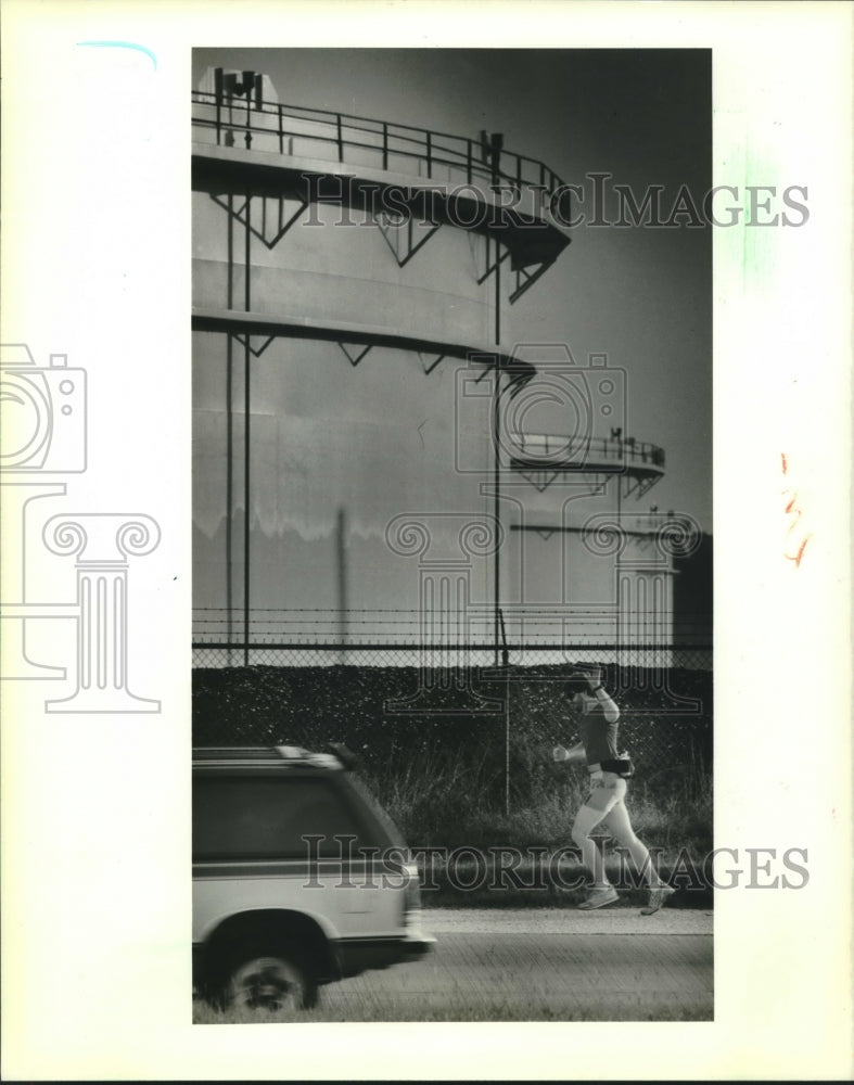 1988 Press Photo Marathon Runner Paul Dendy Runs at Judge Perez Drive Oil Tank - Historic Images