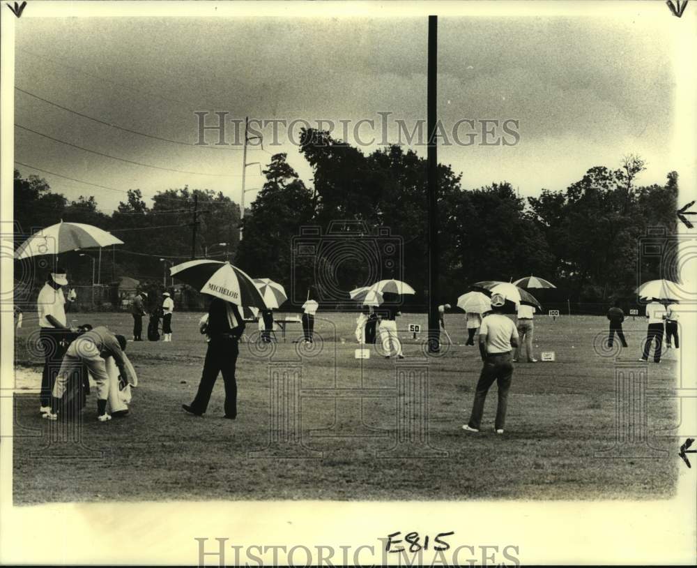 1979 Press Photo New Orleans Open golfers use umbrellas to practice at Lakewood - Historic Images