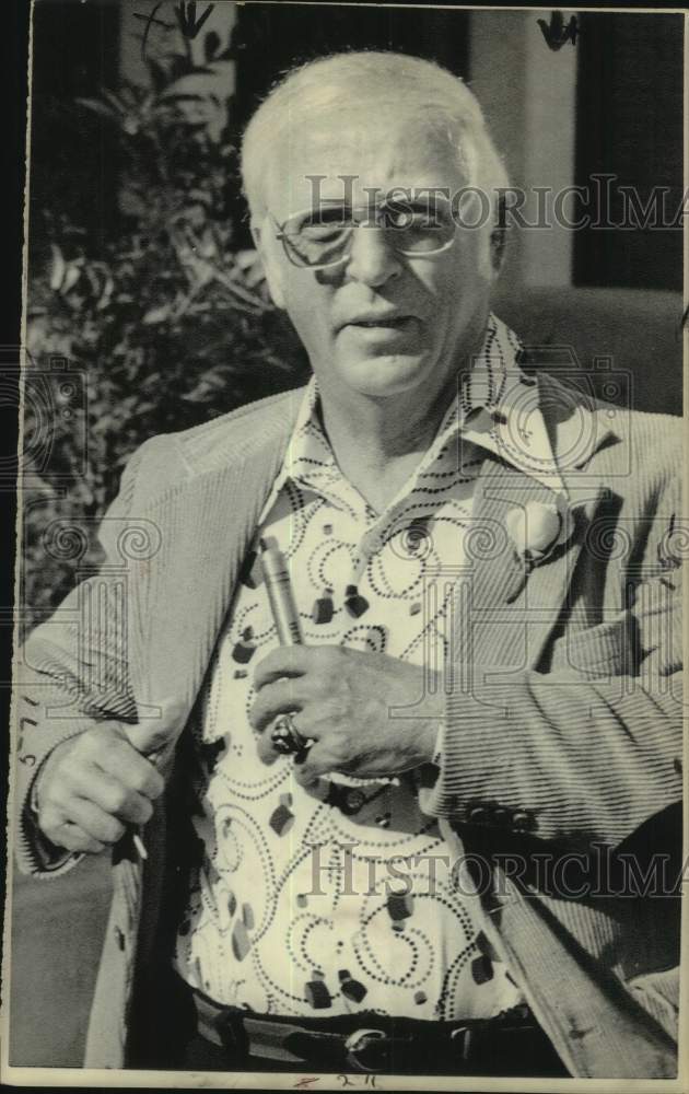 1975 Press Photo UCLA football coach John McKay puts item in suit coat pocket - Historic Images