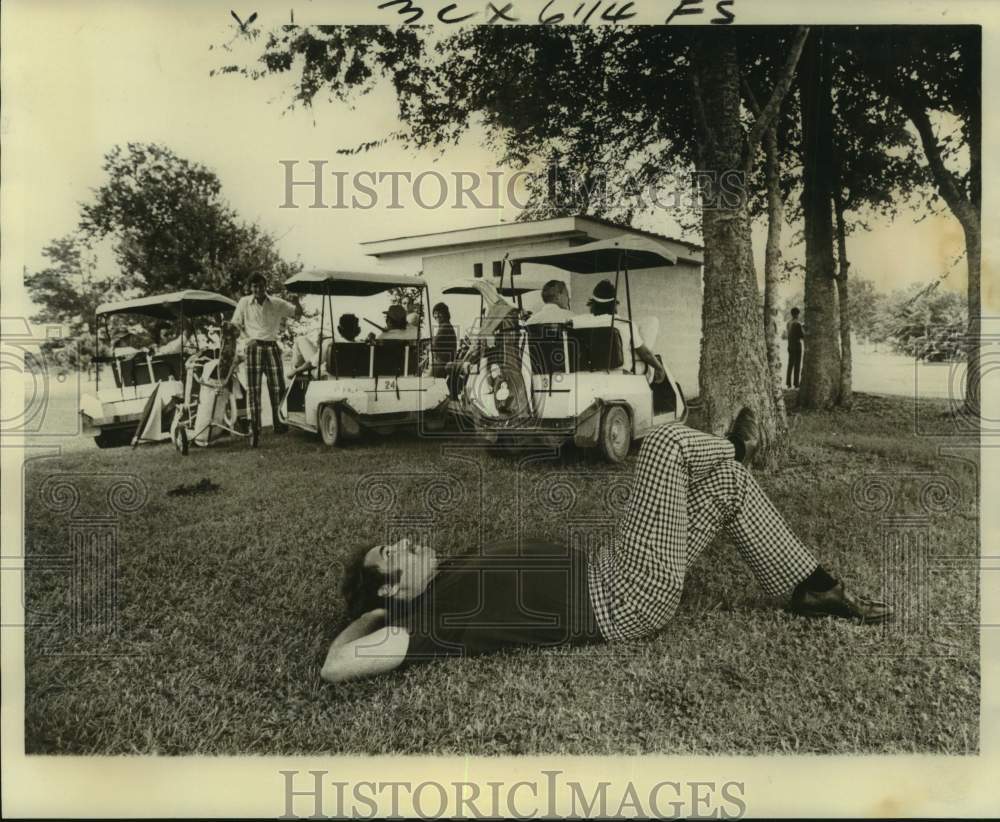 1975 Press Photo Golfer Ken Langenbeck lays down on ground during rain delay - Historic Images