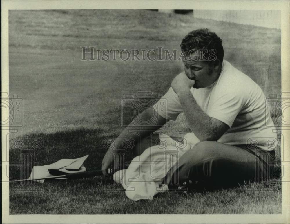 1969 Press Photo Golfer Bob Murphy sits on the grass next to the putting green - Historic Images