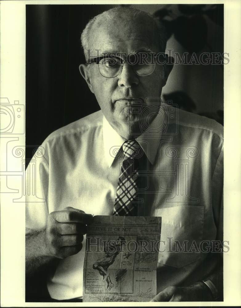 1985 Press Photo Dr. Marshall Michel holds up Ripley&#39;s newspaper clipping - Historic Images