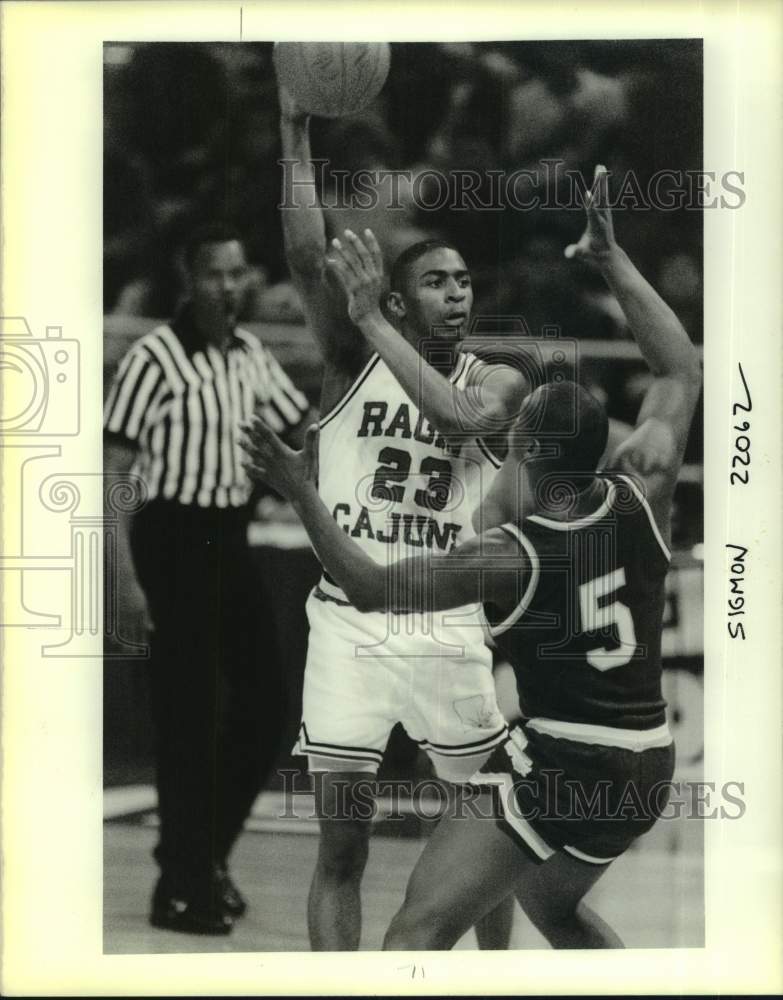 1990 Press Photo Ragun Cajuns basketball player Aaron Mitchell #23 looks to pass - Historic Images