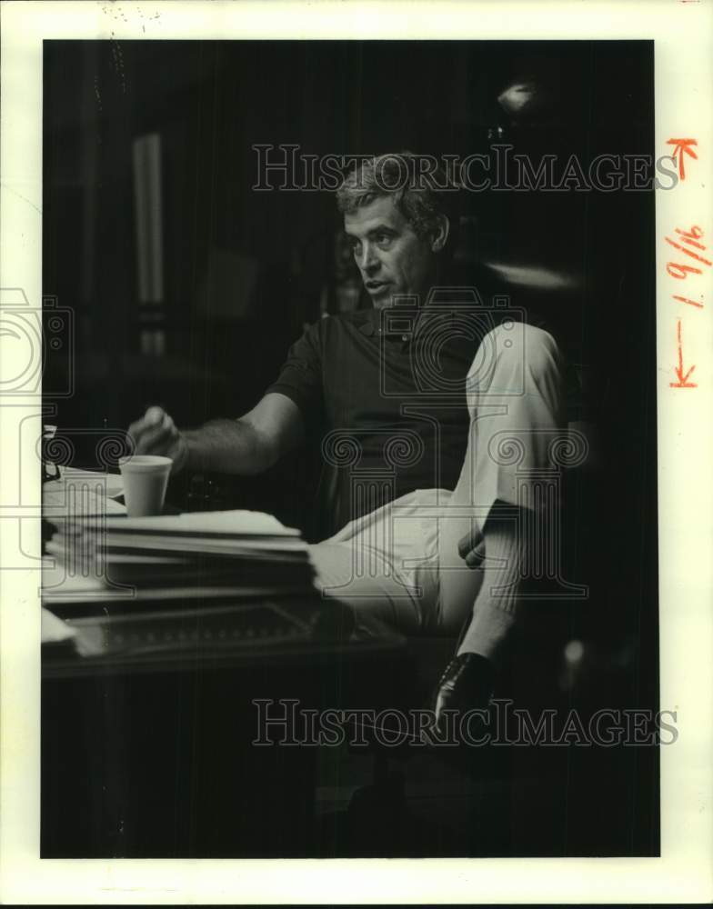 1986 Press Photo New Orleans Saints football coach Jim Mora sits behind his desk- Historic Images