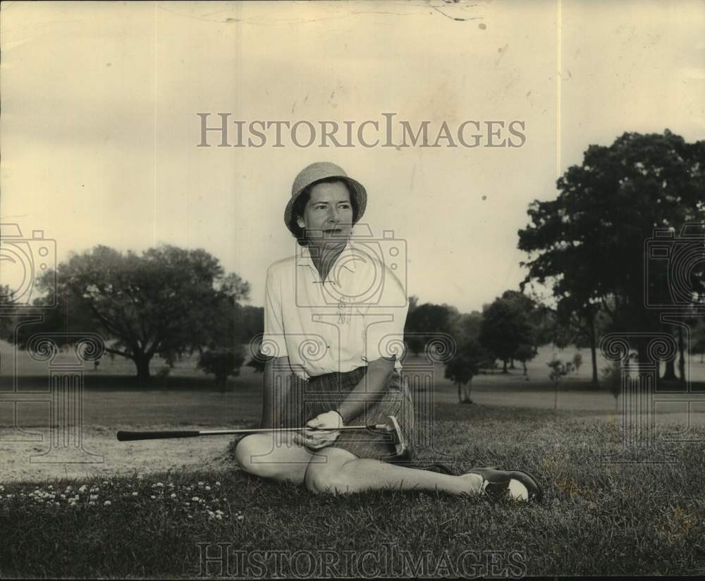 Press Photo Mrs Robert Monsted sits down on the golf course holding her putter - Historic Images