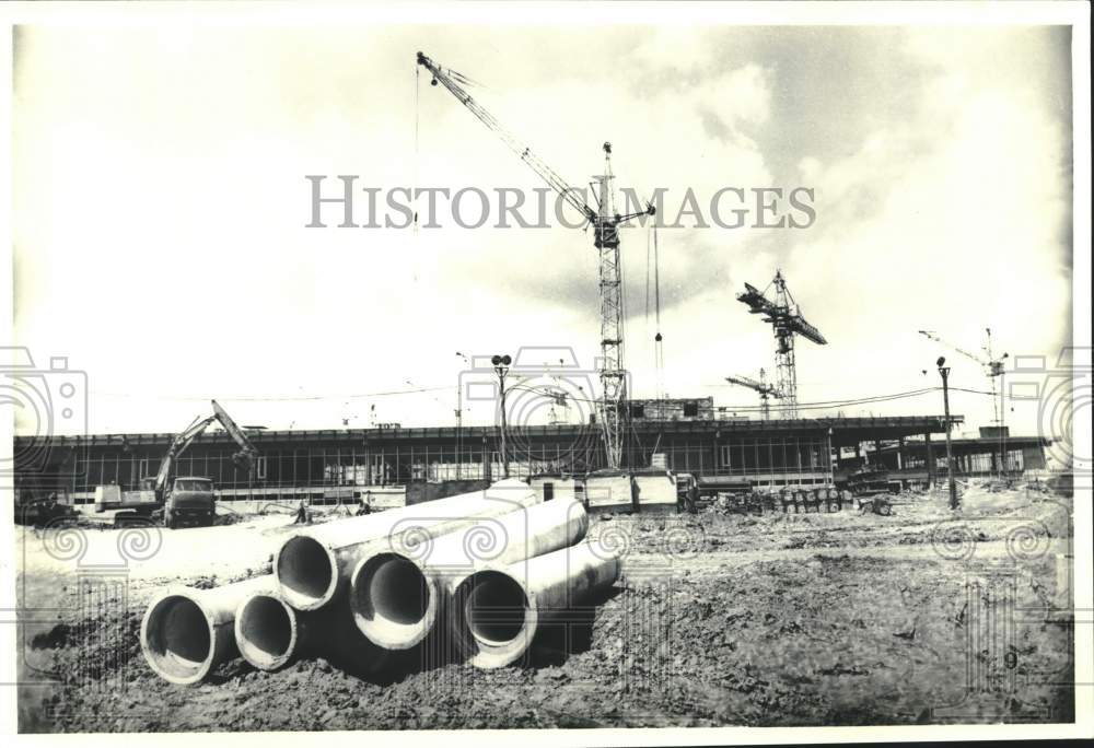 Press Photo Pipes sit in front of Olympic building under construction in Russia - Historic Images