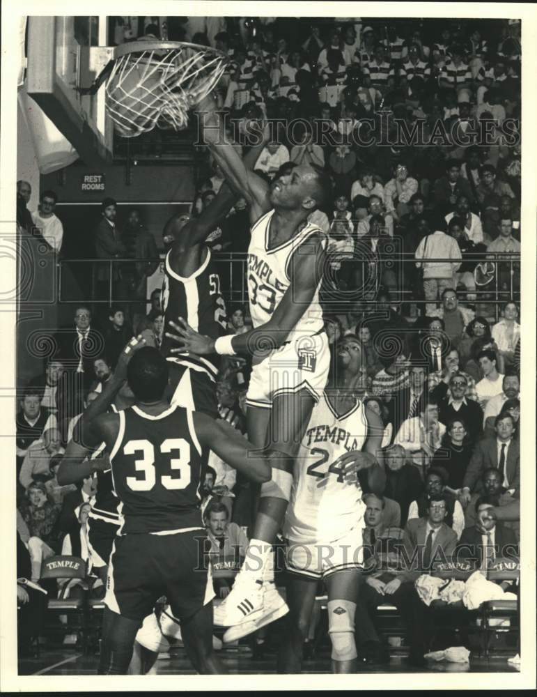 1989 Press Photo Temple basketball player Tim Perry dunks the ball over defender- Historic Images