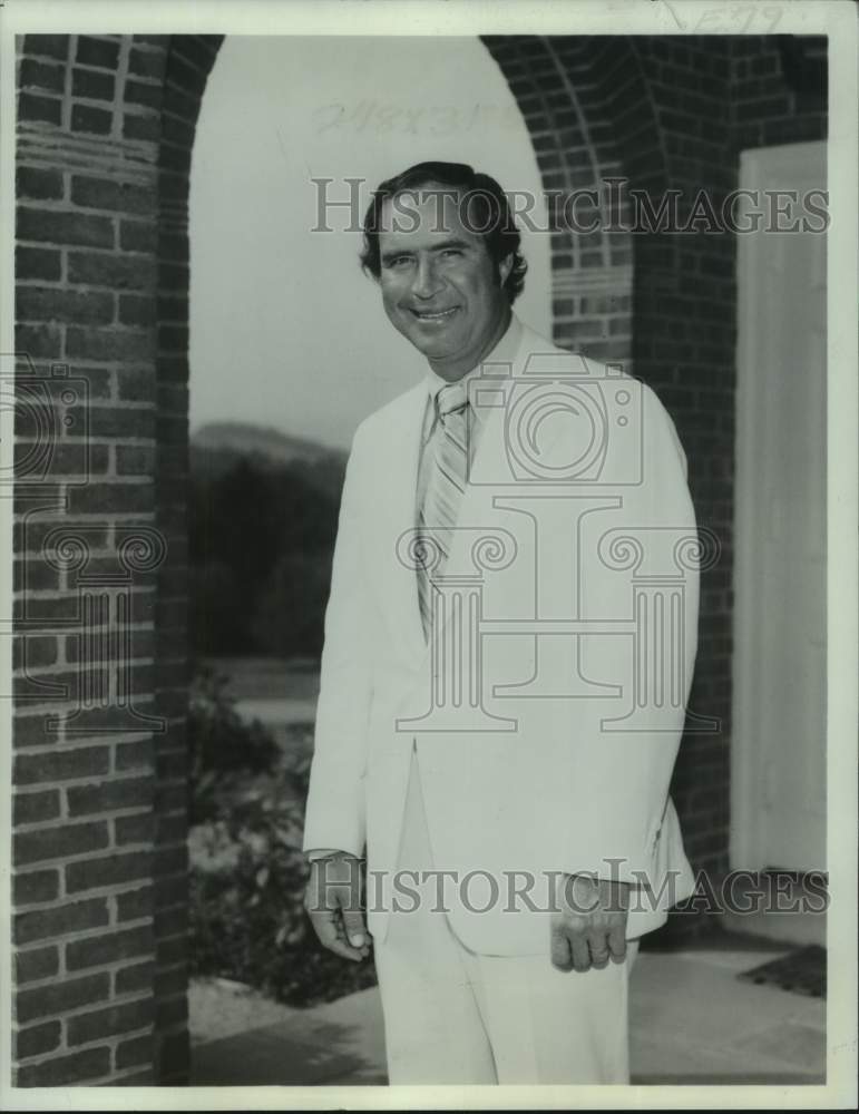 1976 Press Photo Golfer Johnny Pott stands by brick archway wearing suit and tie- Historic Images