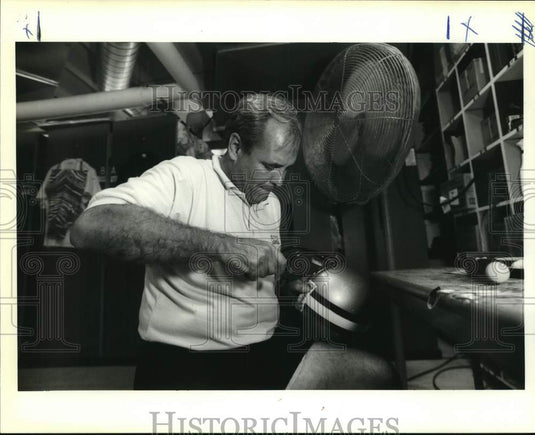 1990 Press Photo Saints' football equipment manager Dan Simmons enhances helmets- Historic Images