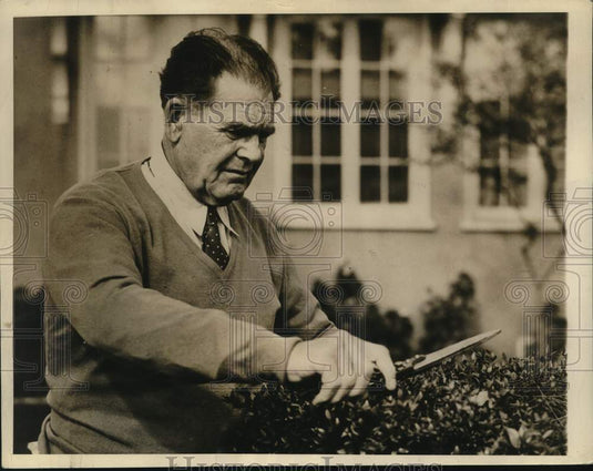 1934 Press Photo Famed college football coach "Pop" Warner trims his hedge - Historic Images