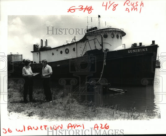 1986 Press Photo Auctioneers Lyn Brown and Timothy L. Mutz standing by Boat - Historic Images