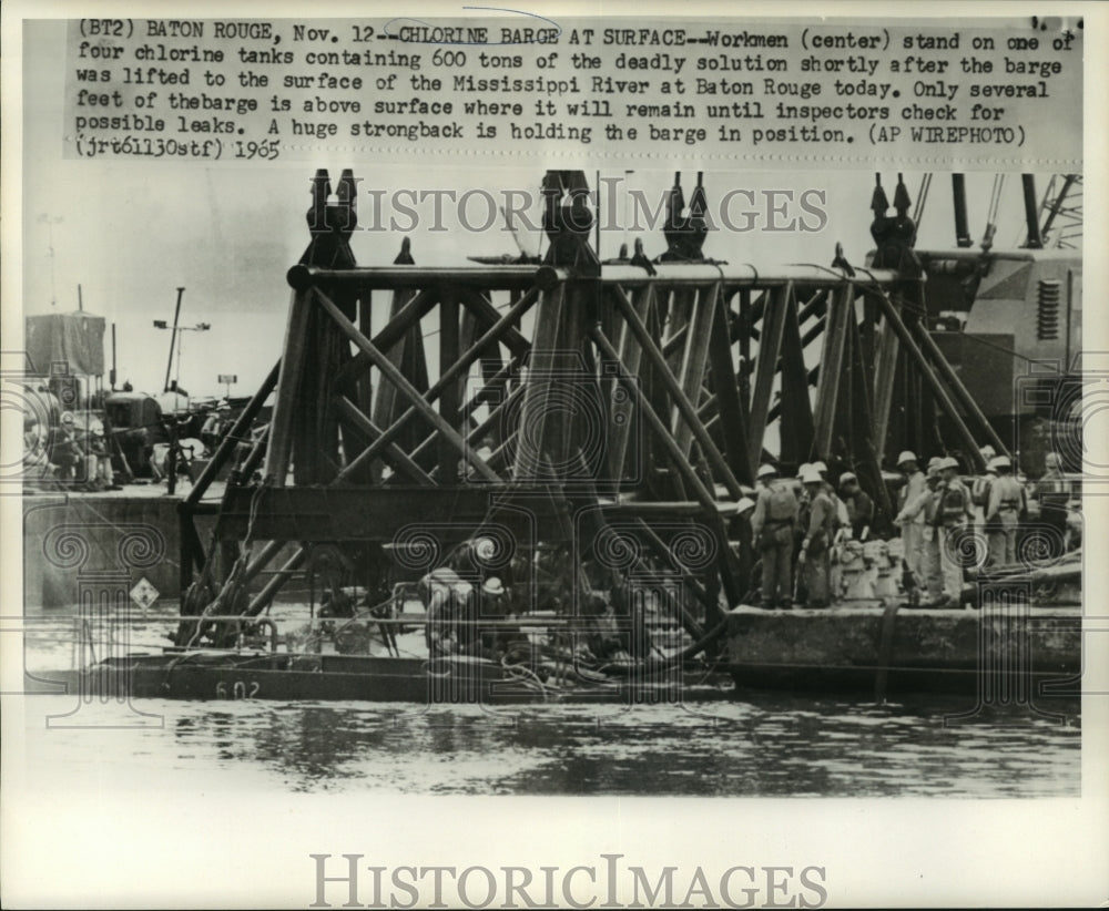 1965 Press Photo Workmen stand on a chlorine tank recently pulled from the water-Historic Images