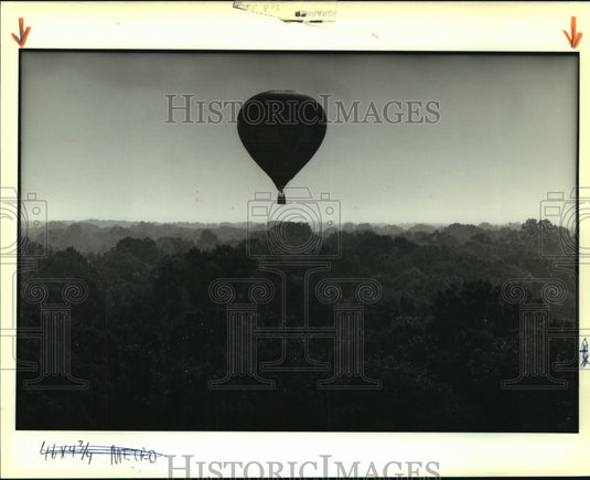 1989 Press Photo A hot air balloon lazily drifts over trees near Baton Rouge - Historic Images