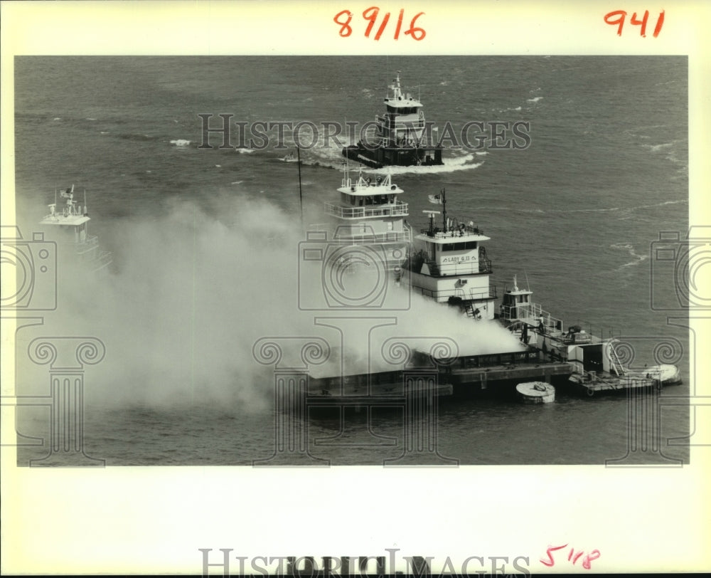 1989 Press Photo Barges circle a pair of burning grain barges in the Mississipi - Historic Images