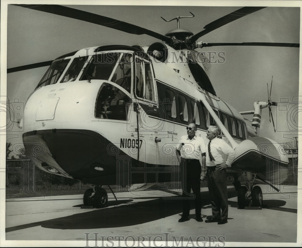 Press Photo Petroleum Helicopters president, vice president inspect a helicopter - Historic Images