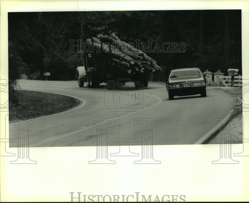 1989 Press Photo A car follows a log truck into Deadman&#39;s curve near Covington - Historic Images