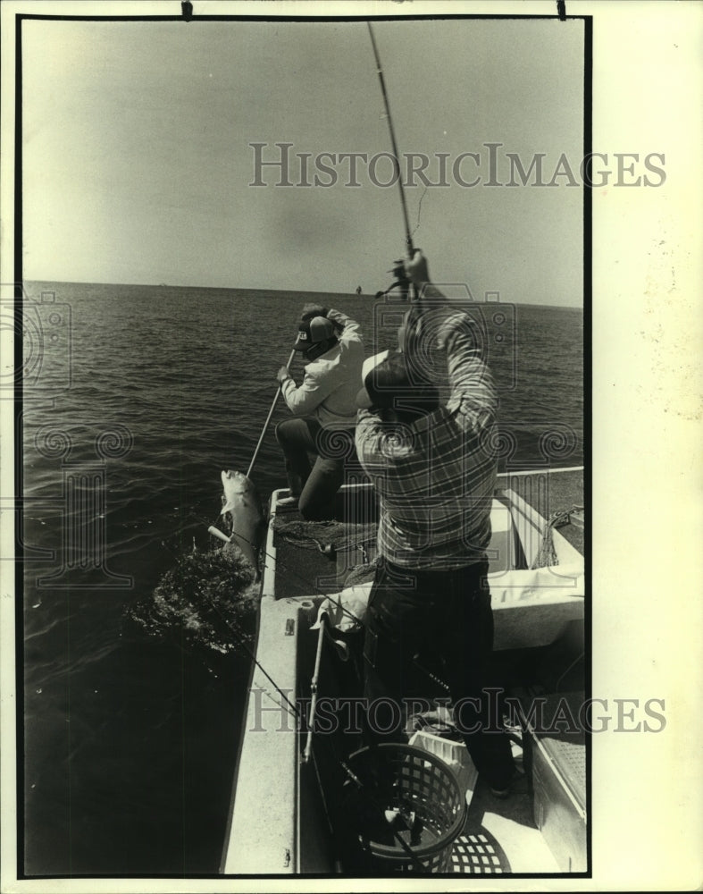 1989 Press Photo Fisherman Jack Crevalle reels a large fish out of the water - Historic Images