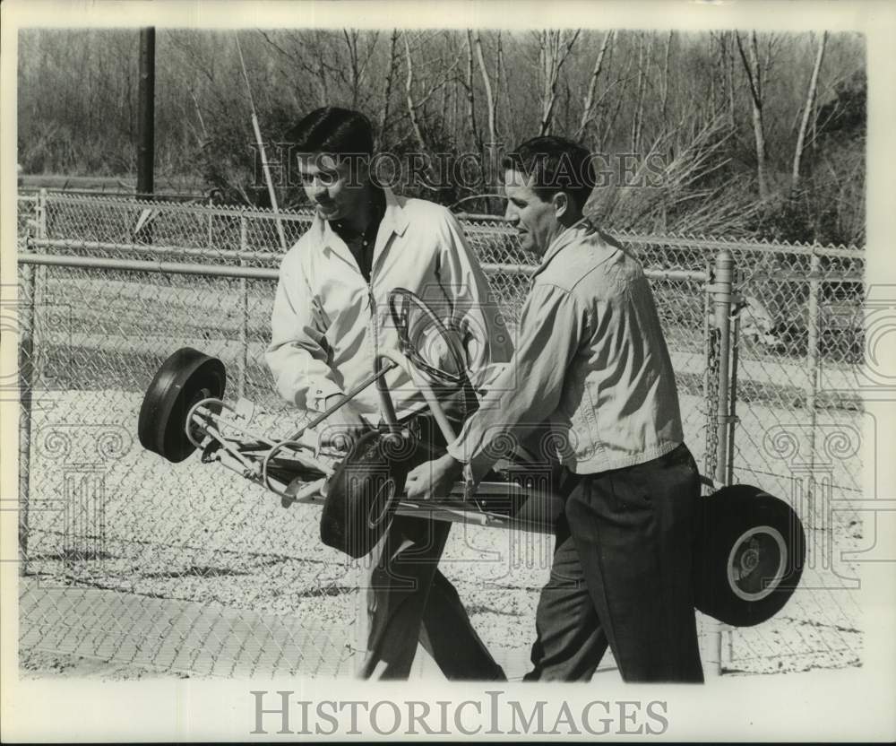 1961 Press Photo A go-kart being carried by two men - not06236- Historic Images
