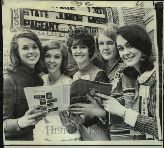 1968 Jane Foshee, reigning Junior Miss & contestants look at program - Historic Images