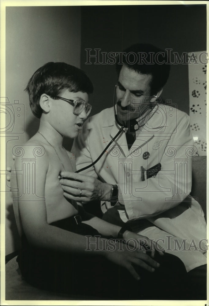 1989 Press Photo Dr. Frank Franklin examines Christopher Crusta at hospital-Historic Images