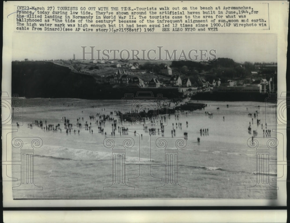 1967 Arromanches, France tourist for &quot;the tide of the century.&quot; - Historic Images