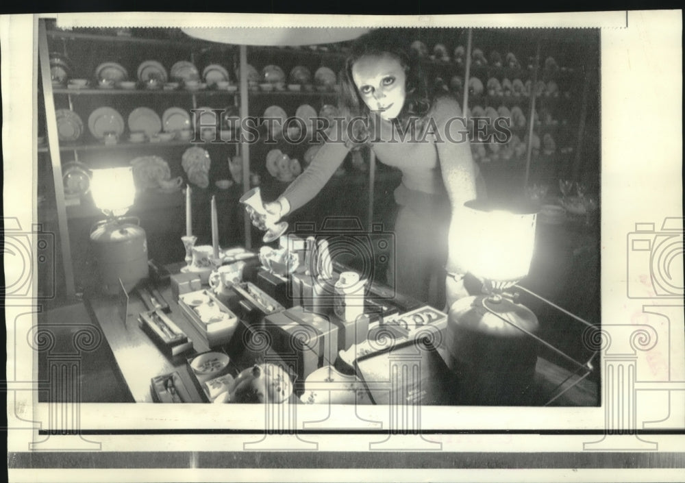 1973 Judith Whitten uses camping lanterns to check prices in store - Historic Images