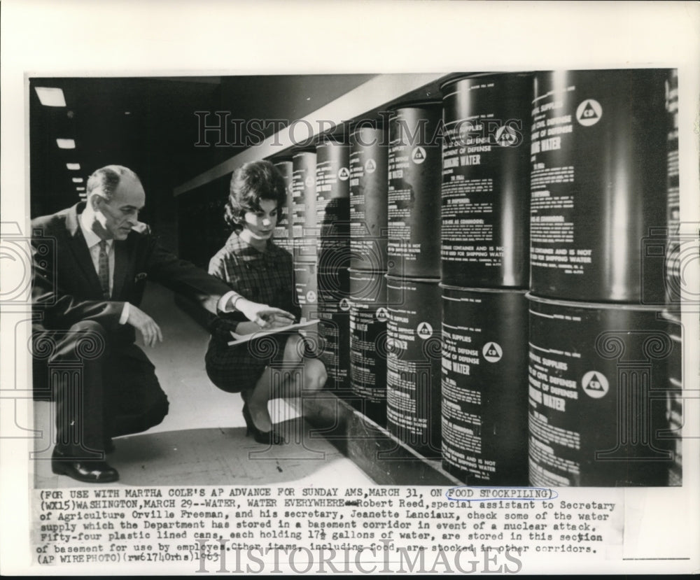 1963 Robert Reed &amp; secretary check food stockpiles in basement - Historic Images