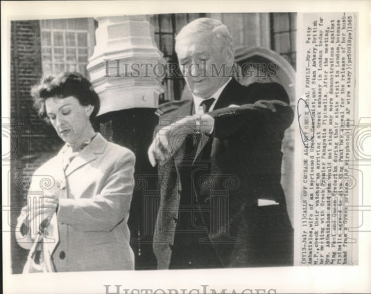 1963 Betty Ambatielos & Awbery check their watches at Greek embassy - Historic Images
