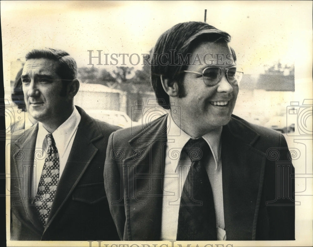 1974 Clausius James Giesick smiles as escorted to New Orleans jail. - Historic Images