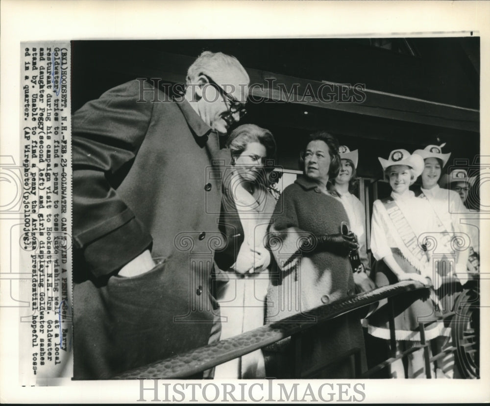 1964 Senator Barry Goldwater searches for penny for wishing well - Historic Images