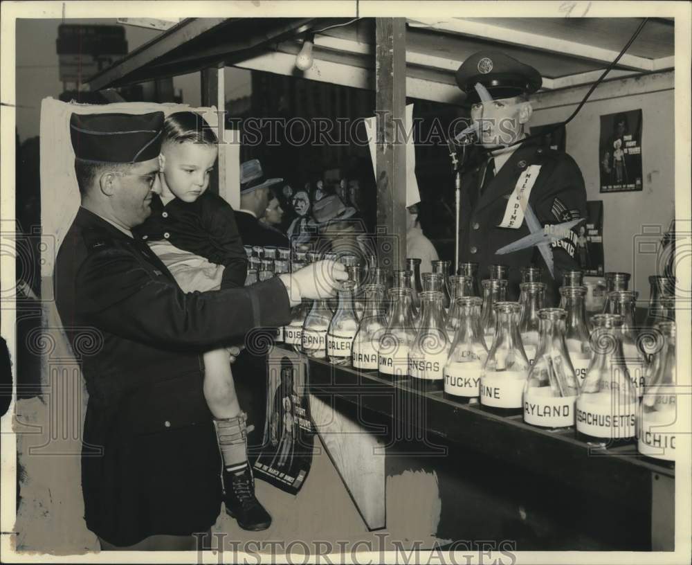 1952 Arthur Hattier, polio victim, has help places dimes in bottles - Historic Images