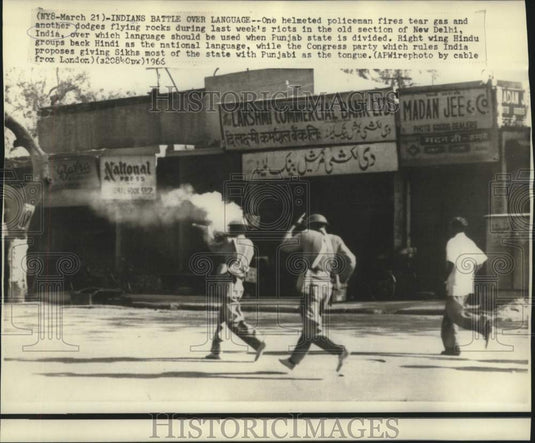 1966 Policemen fire tear gas and dodge rocks in New Delhi riot - Historic Images