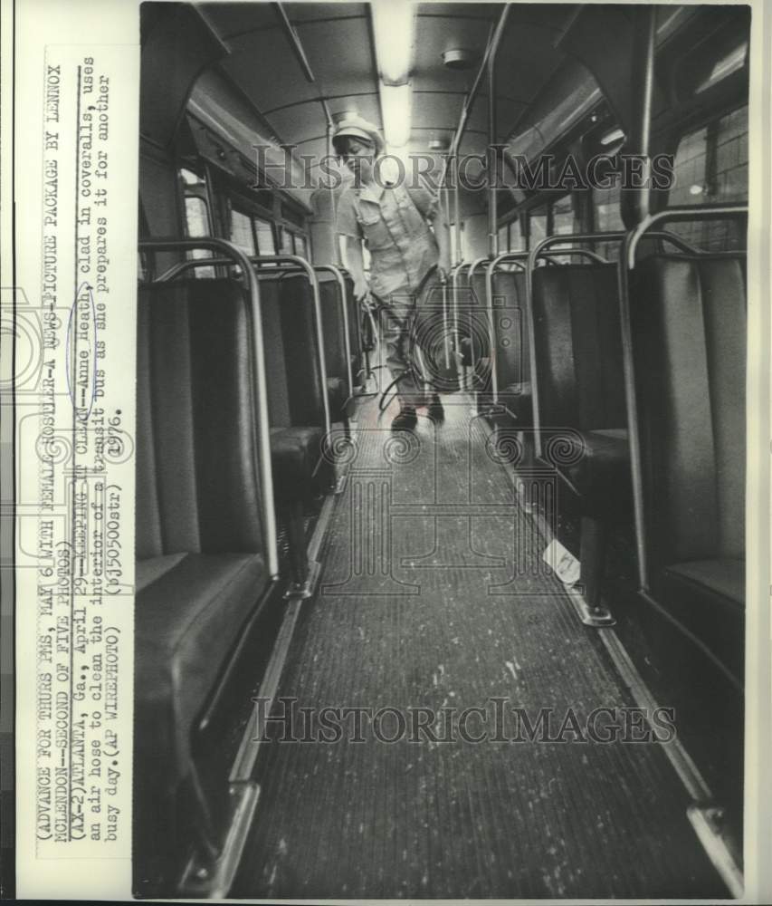 1976 Anne Heath, uses air hose to clean bus interior - Historic Images