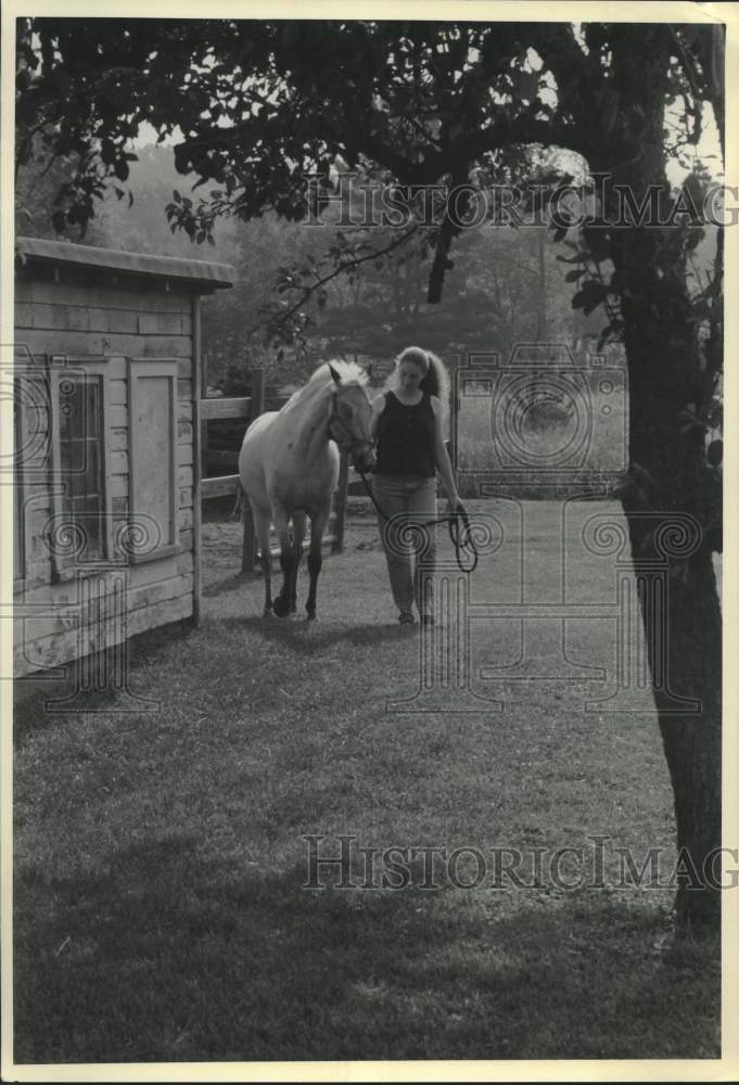 1991 Press Photo Jaimie MacKenzie tends her horse as Home School activity.- Historic Images