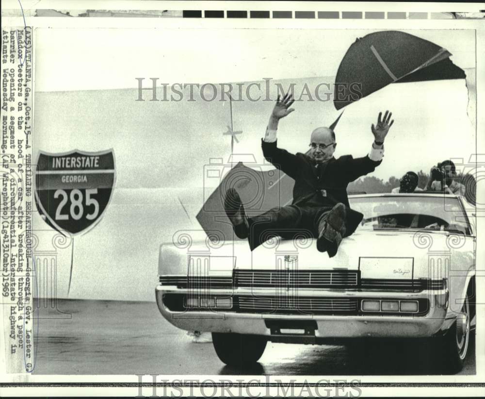 1969 Press Photo Georgia Governor Maddox teeters on car hood at I-285 ceremonies-Historic Images