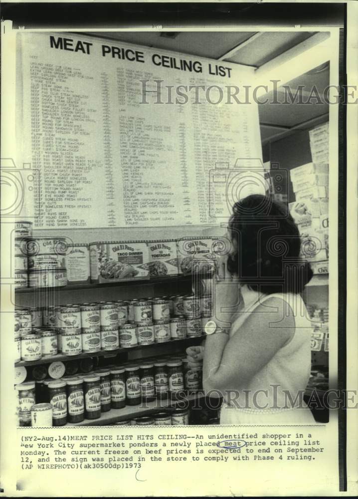 1973 New York City shopper ponders meat price ceiling sign - Historic Images
