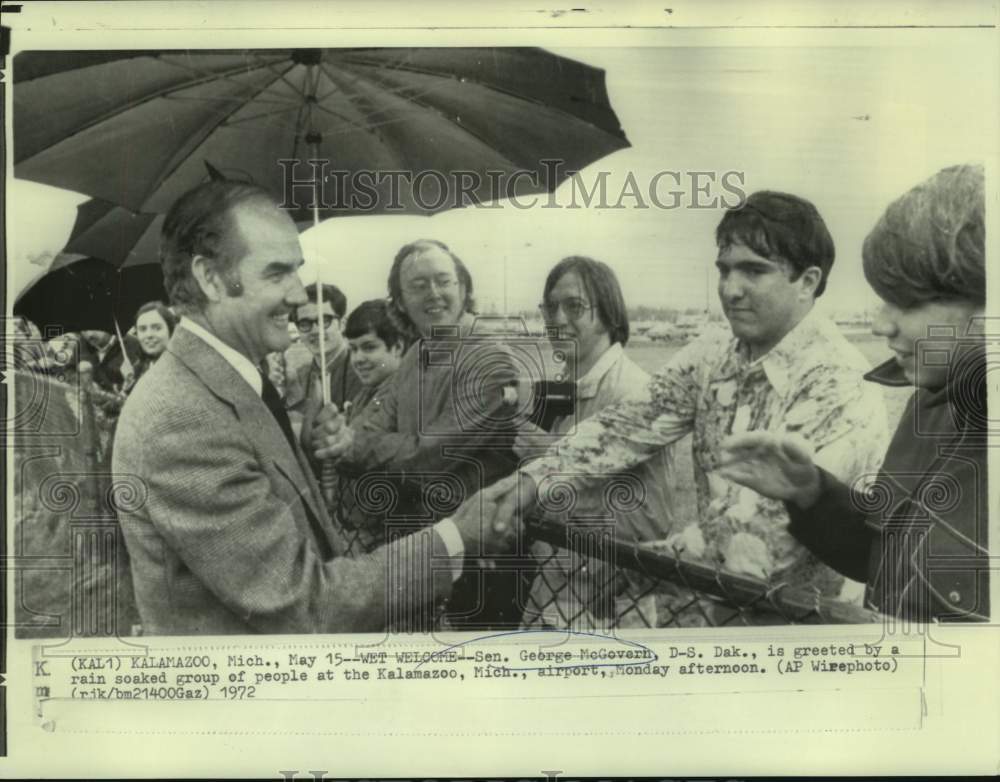 1972 Senator George McGovern greeted by rain soaked supporters in MI - Historic Images