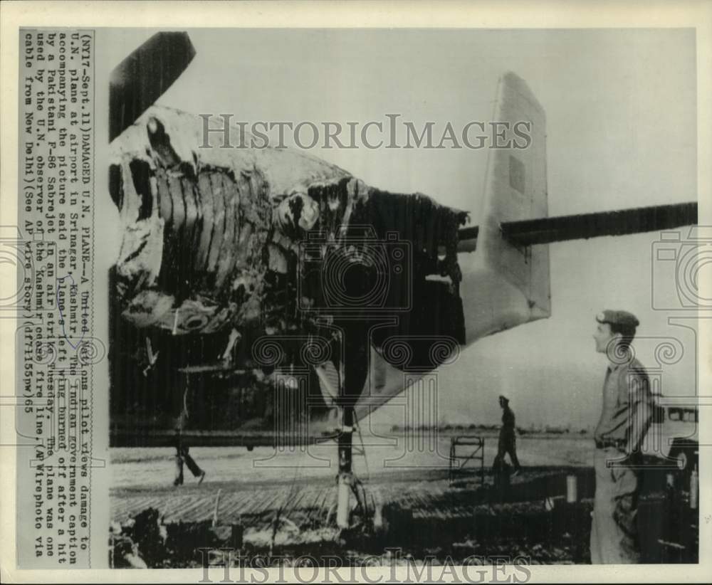 1965 United Nations pilot views damaged UN plane at Kashmir. - Historic Images