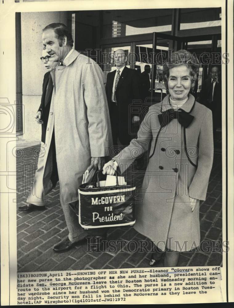 1972 Eleanor McGovern with new purse as she and husband leave hotel. - Historic Images