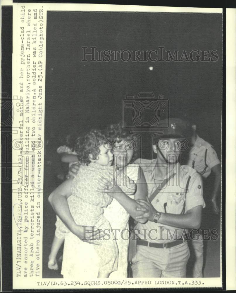 1974 Israeli police officer escorts mother and child from building - Historic Images