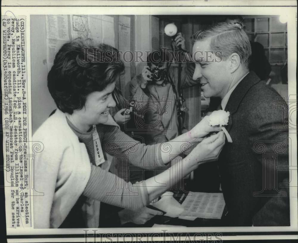 1966 Press Photo Poll worker pins carnation on Charles Percy before he votes - Historic Images