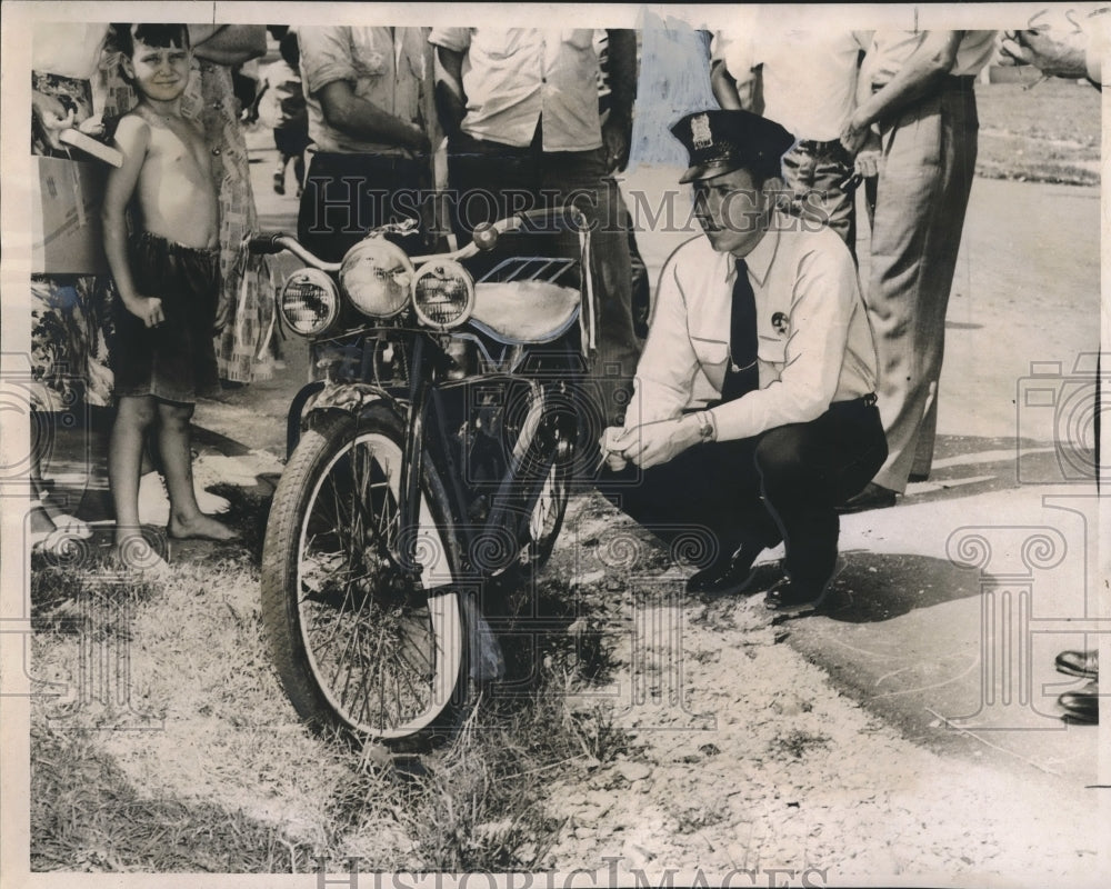 1950 Press Photo Patrolman Leon Belsom examines motorbike involved in accident- Historic Images