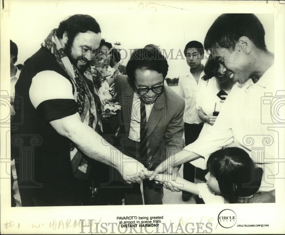 1988 Pavarotti being greeted at airport in Distant Harmony scene - Historic Images