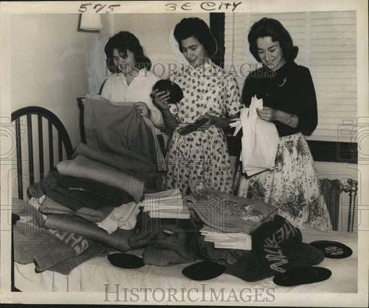 1961 Press Photo Cuban refugees examine donated bedclothing at Ursuline Convent. - Historic Images