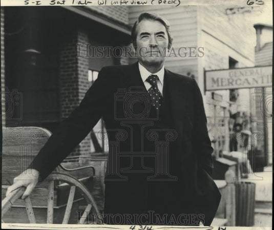 1975 Press Photo Actor Gregory Peck poses beside a General Mercantile store - Historic Images