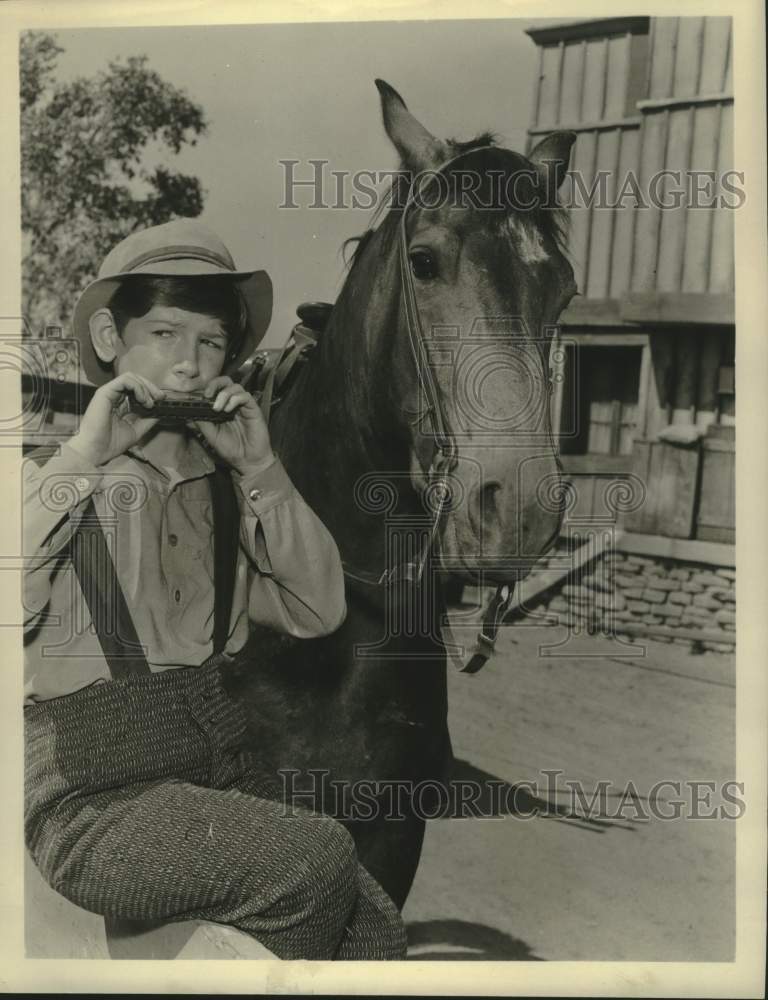 1958 Press Photo Actor Tommy Nolan playing the harmonica. - Historic Images