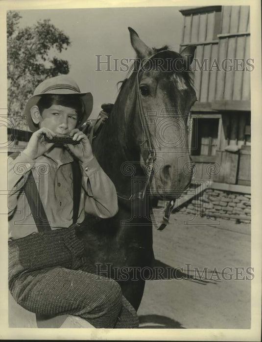 1958 Press Photo Actor Tommy Nolan playing the harmonica. - Historic Images