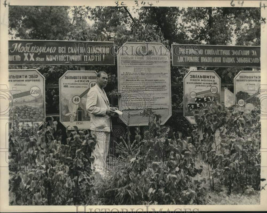 1958 A man stands in front of "Outproduce America" banners near Kiev-Historic Images
